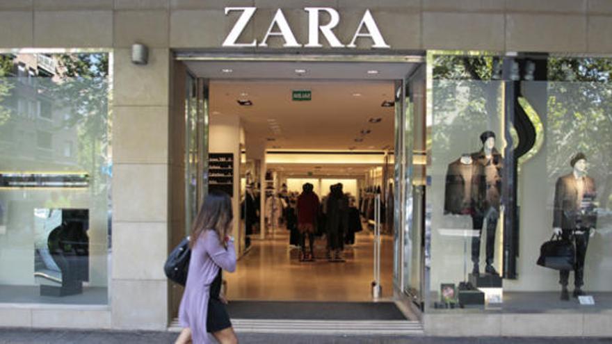 Una chica pasea delante de una tienda de Zara.