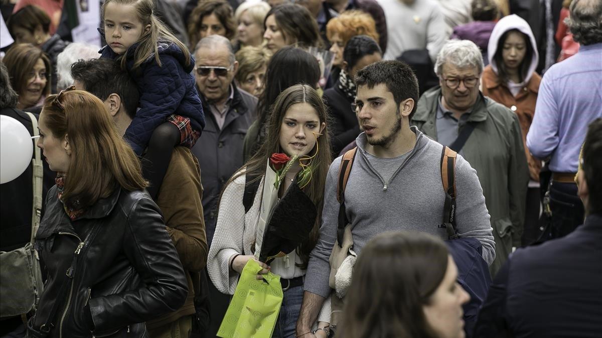 Una pareja pasea entre las paradas de la Rambla de Catalunya.