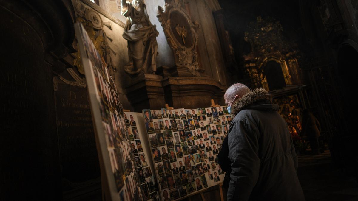 Un hombre reza por los caídos.