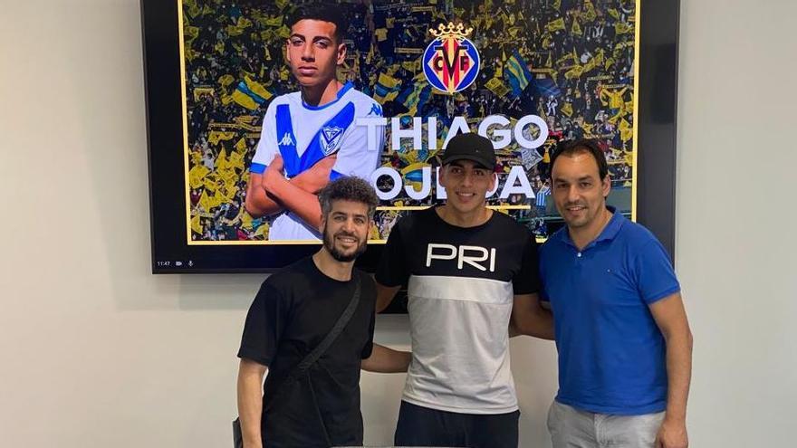 El joven delantero Thiago Ojeda, en el centro, junto al  director de fútbol del Villarreal CF, Miguel Ángel Tena (d).