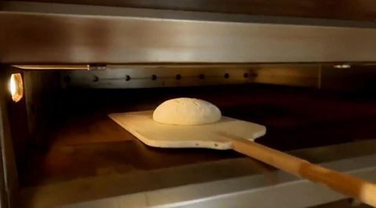 La masa de pan es entrada en un horno.