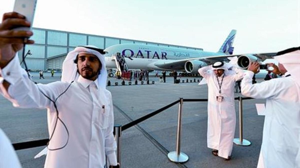 Unos jóvenes catarís se retratan junto al nuevo Airbus A380 de Qatar Airways, el jueves, en Doha.