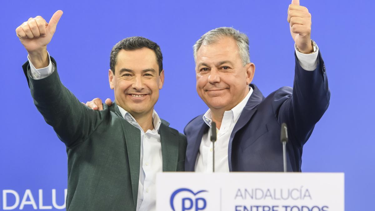 El presidente del PP andaluz, Juanma Moreno (i), junto al candidato a la alcaldía de Sevilla, José Luis Sanz, celebran la victoria en rueda de prensa tras conocer los resultados en la sede popular.