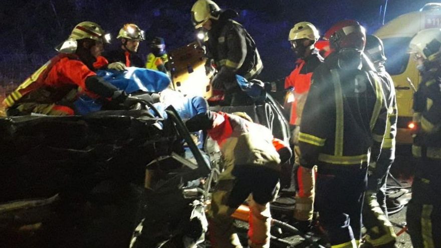 Los bomberos tratan de excarcelar a uno de los atrapados en el accidente de El Caleyo.| SEPA