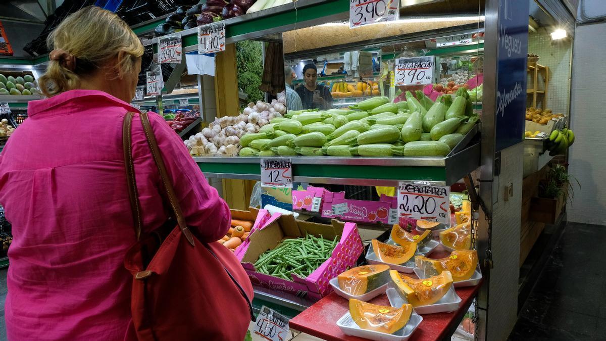 Una mujer en un puesto de frutas y verduras