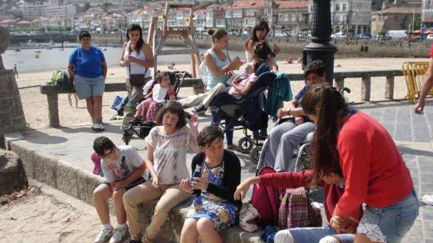 Monitoras y participantes en las jornadas de convivencia, ayer, en la playa de A Ribeira, en Baiona.  // FdV