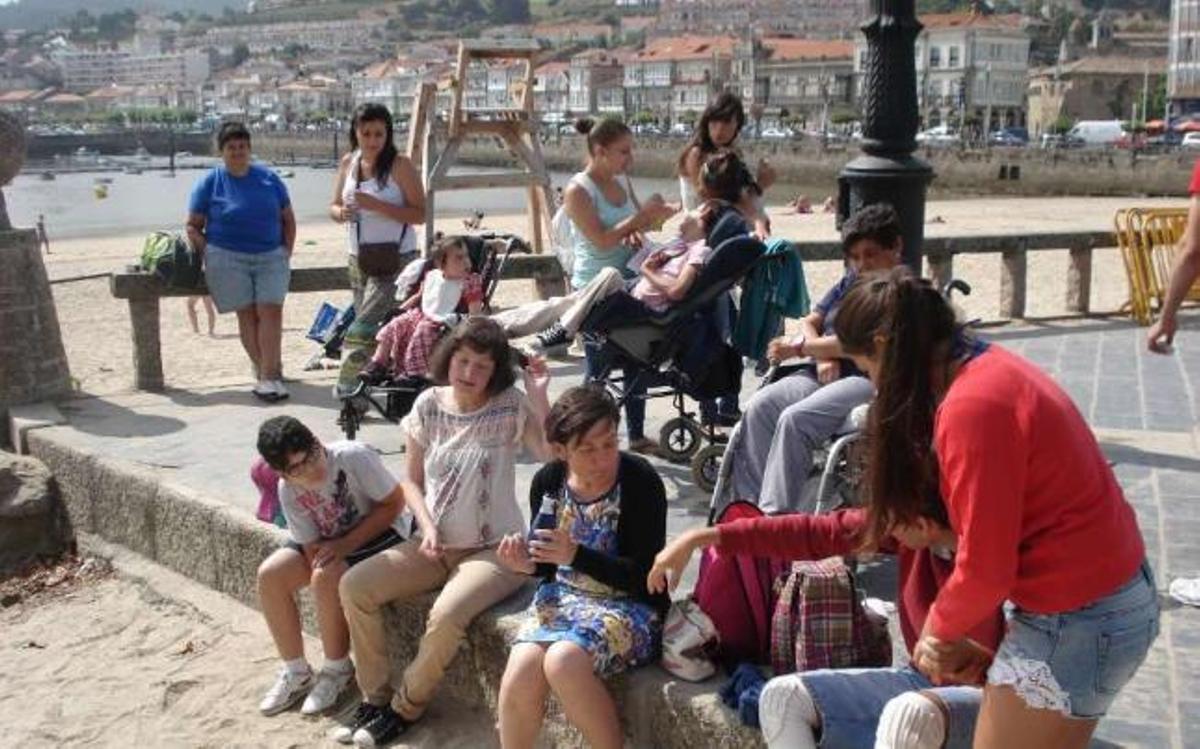 Monitoras y participantes en las jornadas de convivencia, ayer, en la playa de A Ribeira, en Baiona.  // FdV