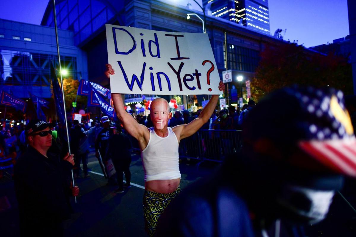 A Trump supporter wears a mask of U.S. Democratic presidential nominee Joe Biden and carries a sign during a protest outside of the Philadelphia Convention Center, where votes are still being counted two days after the 2020 U.S. presidential election, in Philadelphia, Pennsylvania, U.S. November 5, 2020.  REUTERS/Mark Makela