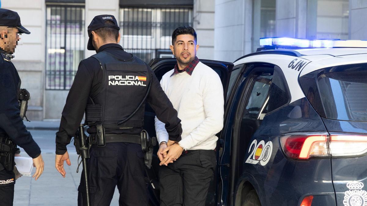 El acusado de agredir a su pareja con un cúter en Alicante al llegar custodiado por la Policía al juicio celebrado en la Audiencia.