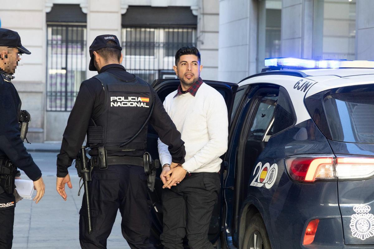 El acusado de agredir a su pareja con un cúter en Alicante al llegar custodiado por la Policía al juicio celebrado en la Audiencia.