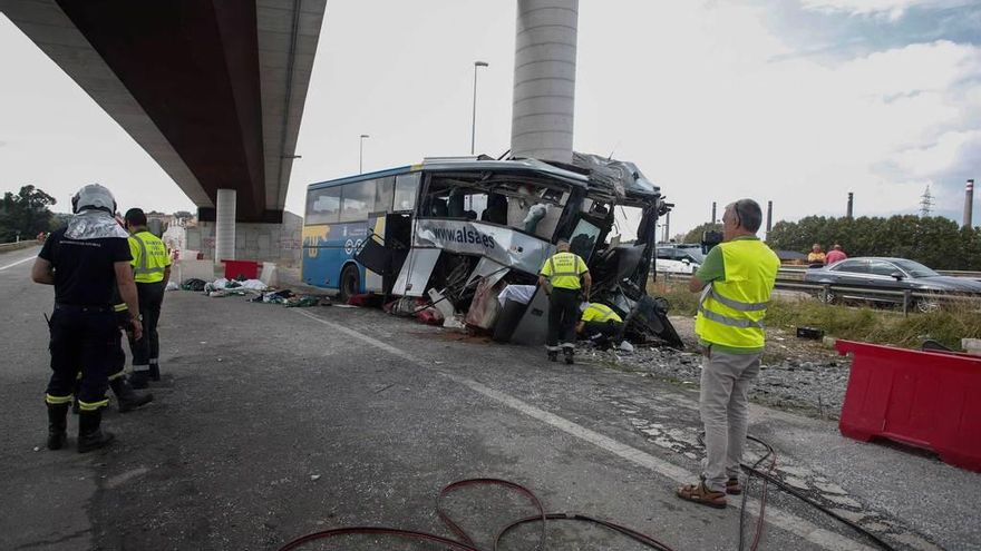 Agentes y bomberos junto al autocar siniestrado.