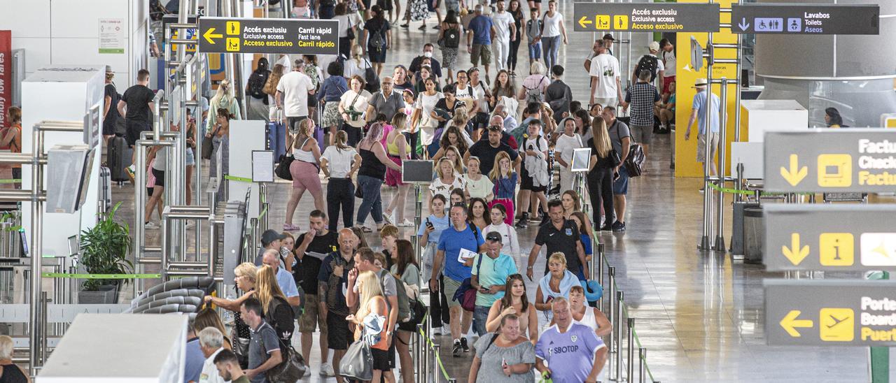Pasajeros en el aeropuerto Alicante-Elche esperan para tomar su vuelo.