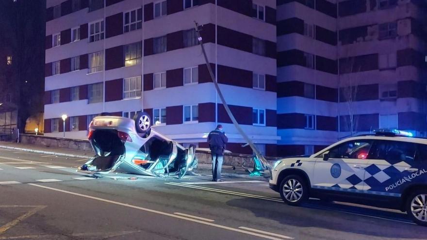 El turismo, volcado en la avenida de Monelos, tras derribar un semáforo. | // ELOYTP