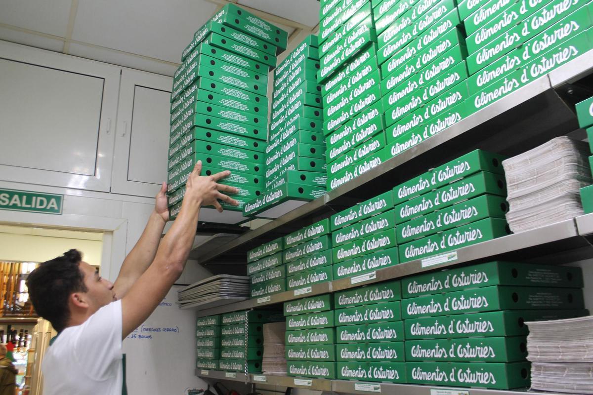 Un empleado, colocando cajas para las empanadas.