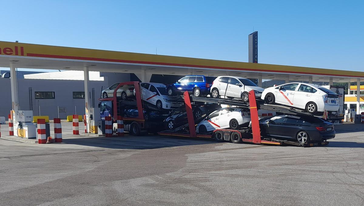 Un camión góndola que transporta tres taxis de Madrid reposta en una gasolinera de la frontera con Francia en su camino a Rumanía. 