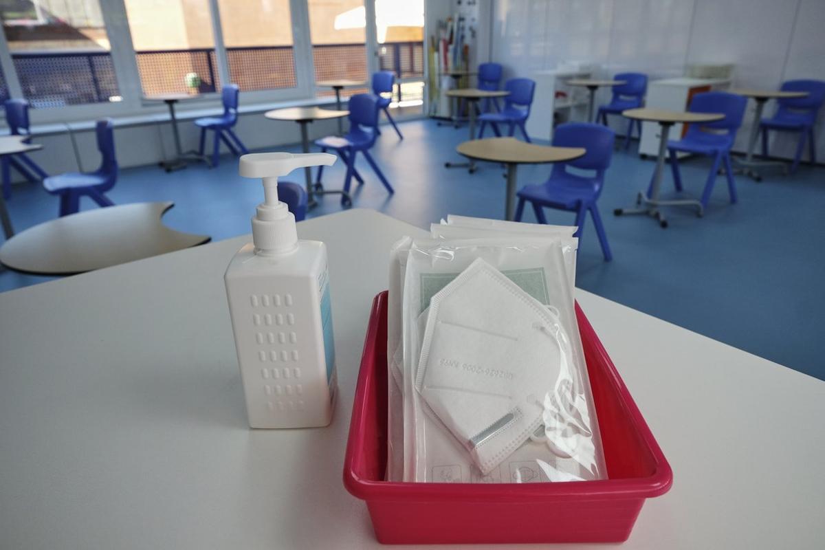 Mascarillas y gel desinfectante en la mesa del profesor de un aula donde se pueden observar los pupitres colocados y separados entre sÃ­ para el nuevo curso del colegio Virgen de Europa, debido a las nuevas medidas de distanciamiento que se han de tomar para evitar nuevos contagios de Covid-19. En Boadilla del Monte, Madrid, (EspaÃ±a), a 19 de mayo de 2020.