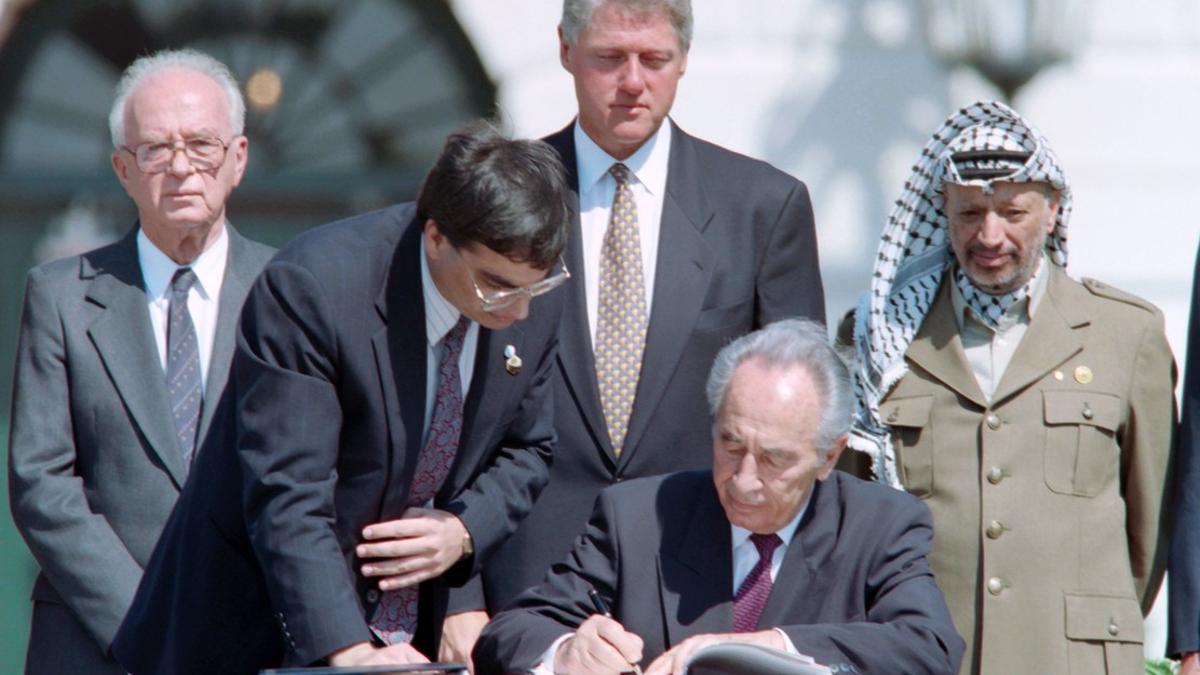 Peres firma los acuerdos de Oslo, observador, de izquierda a derecha, por Isaac Rabin, Bill Clinton y Yasir Arafat, el 13 de septiembre de 1993.