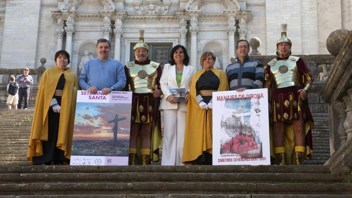 Diversos membres de la Junta de Confraries de Girona en la presentació dels actes de Setmana Santa a Girona als peus de la catedral.