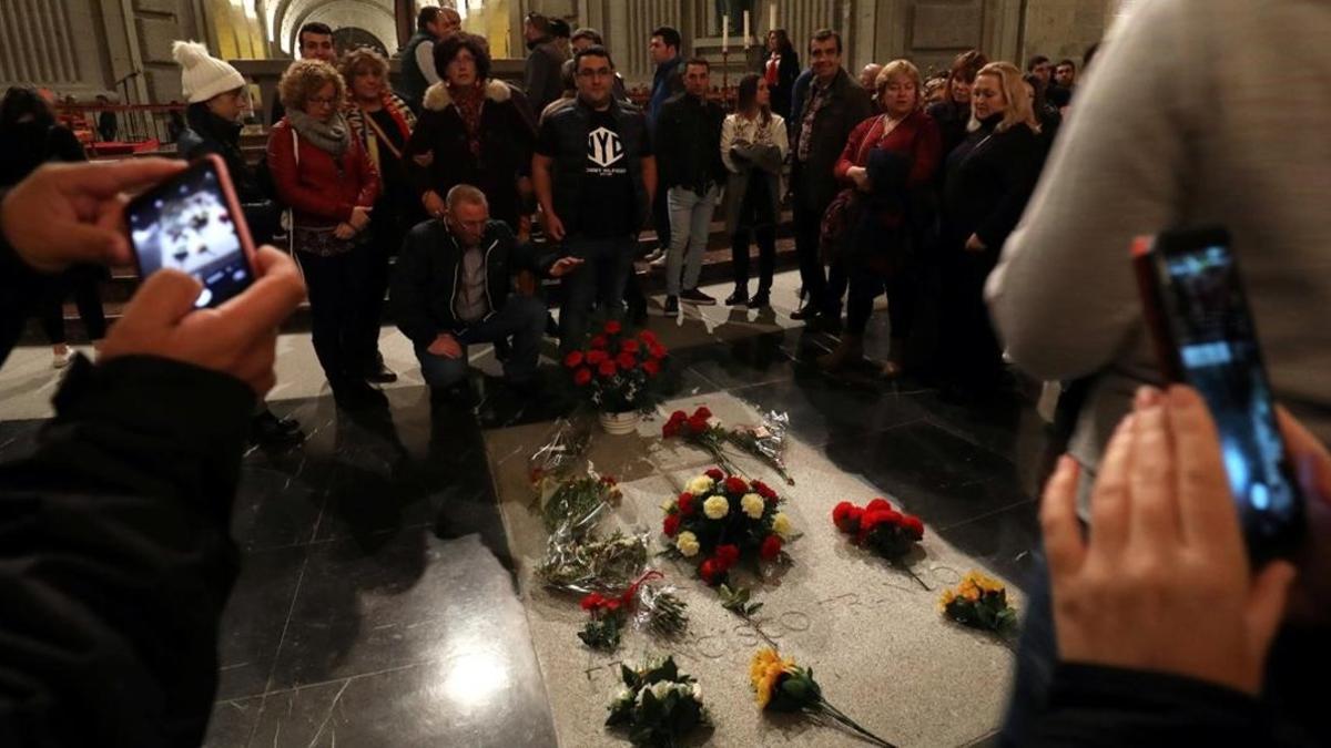 Varios ciudadanos posan ante la tumba de Franco en el Valle de los Caídos, este sábado.