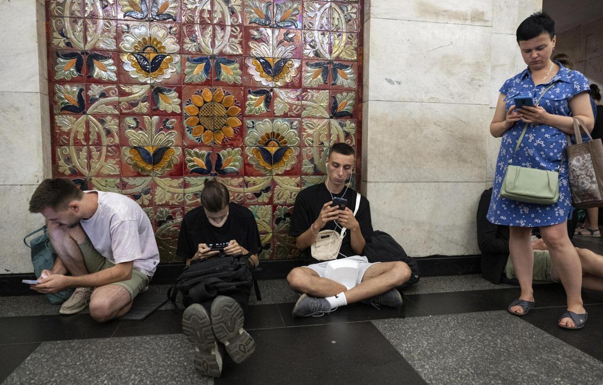 Kiev (Ucrania), 26/08/2024.- Cuatro jóvenes ucranianos se refugian en el metro de la capital en plena alarma aérea, tras detectarse el lanzamiento de una oleada de drones desde Rusia