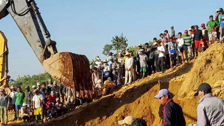 Una excavadora remueve la tierra en busca de desaparecidos.