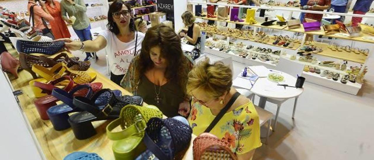 Visitantes en un expositor de calzado en la feria que se está celebrando este fin de semana en Madrid.