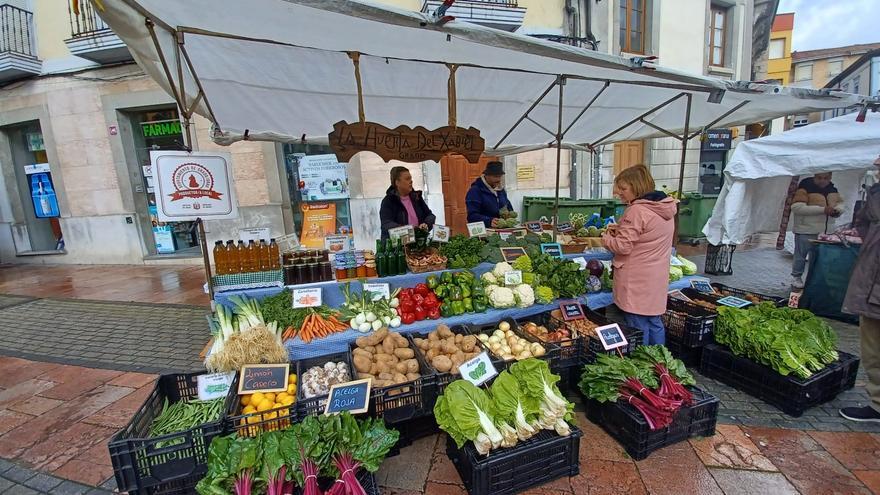 Normalidad relativa en el primer mercado dominical de Grado con el centro en obras, una cita en la que hubo que sacar paraguas