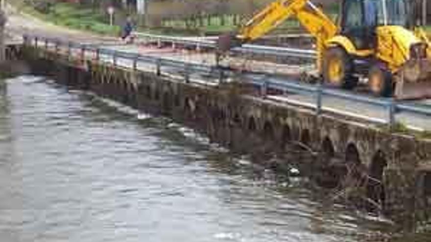 Un operario de la Diputación limpia el puente de Domez, que el viernes fue rebasado por el río Aliste.