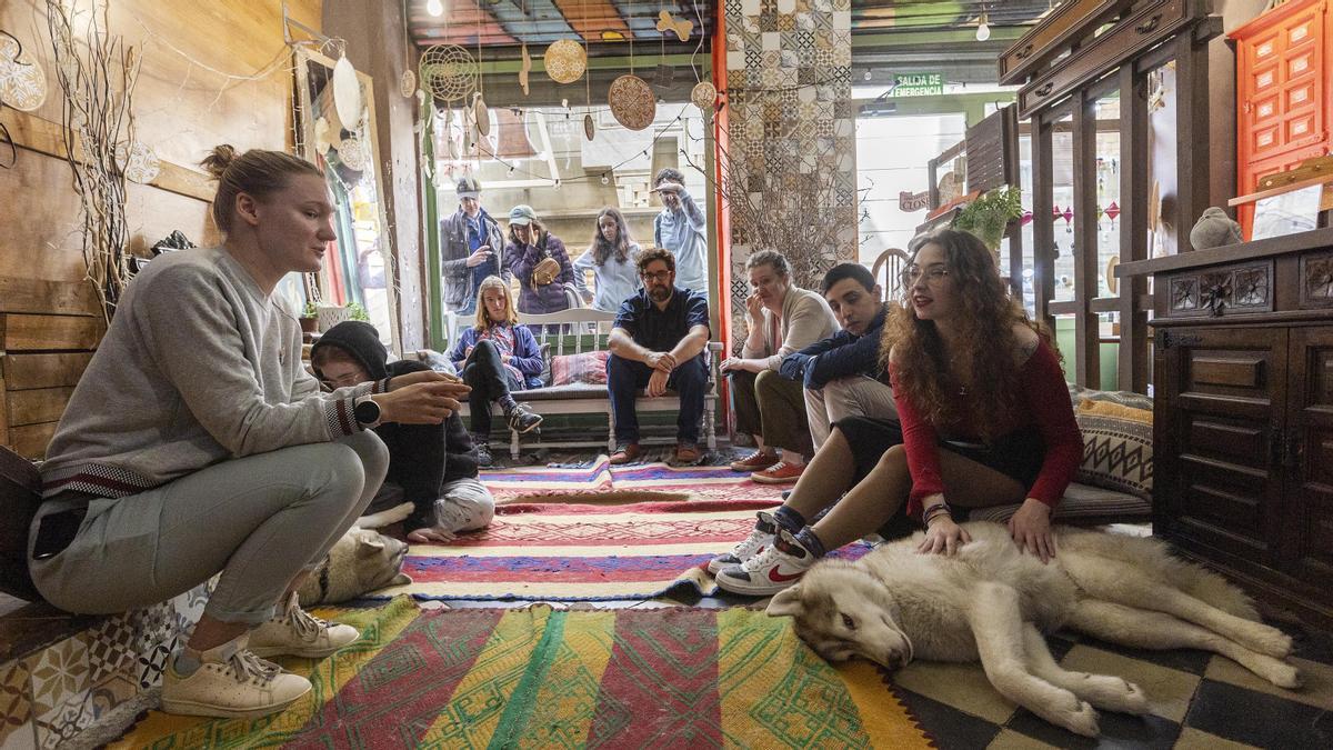 Valentina presenta los huskys a los invitados mientras unos curiosos miran desde el otro lado del escaparate.