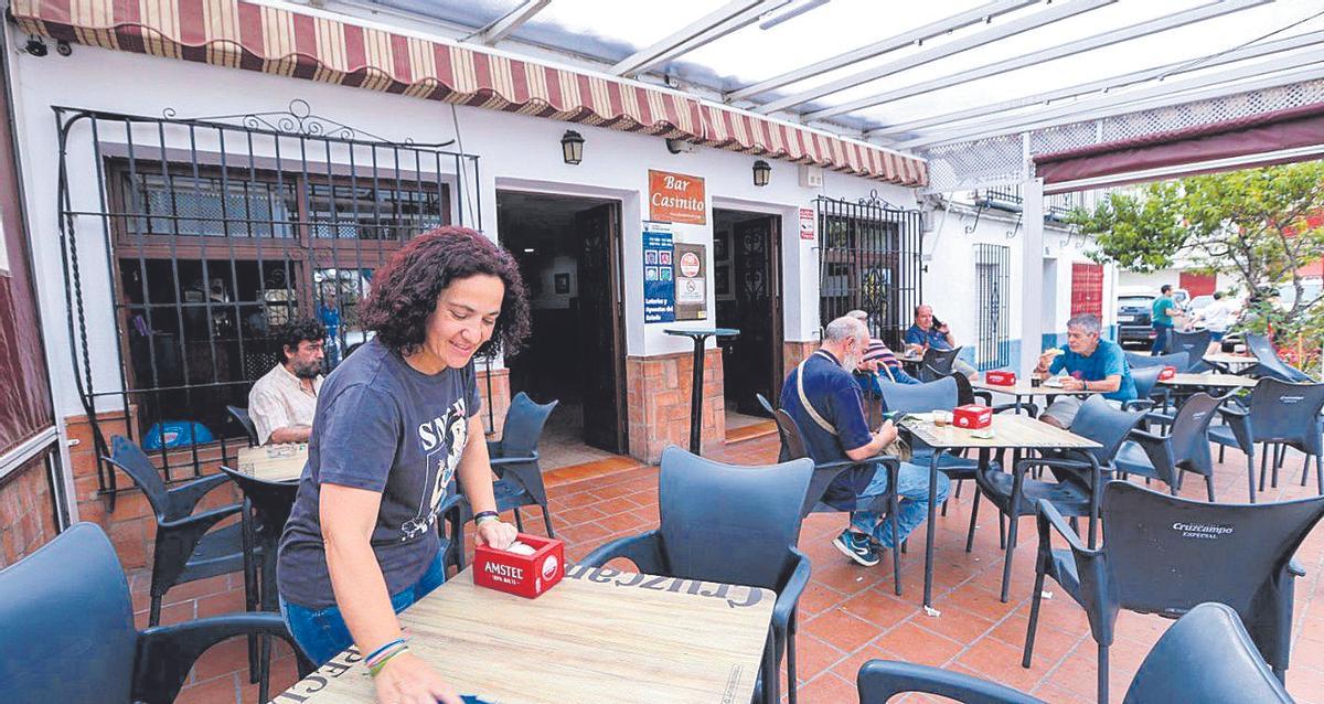 Silvia Gómez, prepara las mesas en el bar El Casinito de Cerro Muriano.