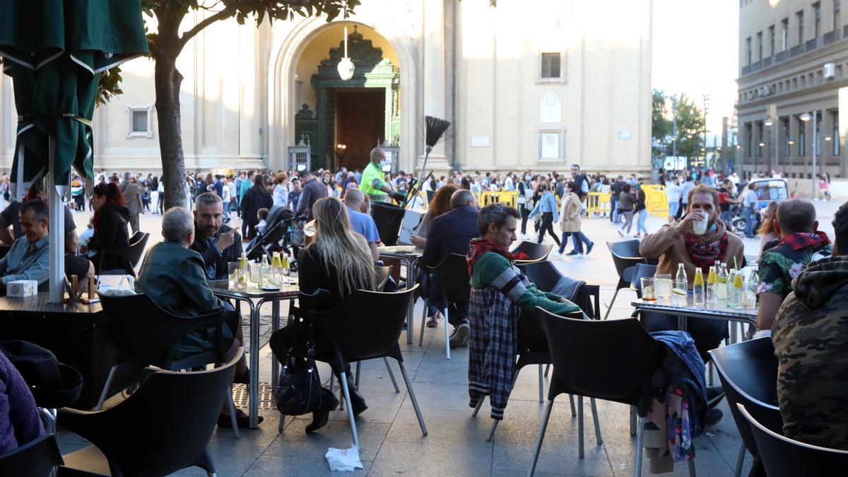 Varias personas toman algo en las terrazas de la plaza del Pilar.