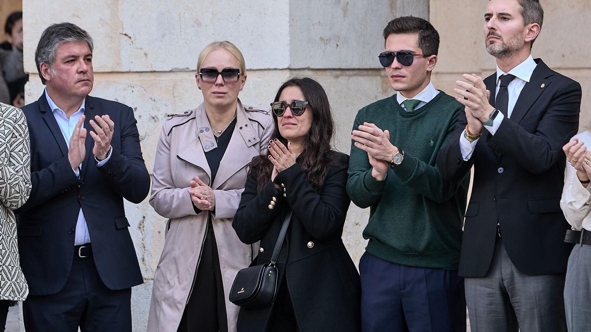 GRAFCVA5657. GANDIA (VALENCIA), 21/02/2025.- La mujer y los hijos del exalcalde de Gandia Arturo Torró entre los que fueron concejales durante su gobierno, Guillermo Barber (i) y Victor Soler, actual diputado y portavoz del grupo popular y presidente del PP en Gandia durante el minuto de silencio convocado por el Ayuntamiento, de luto oficial hasta el sábado, realizado en la plaza Mayor en recuerdo del que fuera alcalde en este municipio con el PP entre 2011 y 2015 y cuyo cadáver con signos de violencia fue hallado este jueves, un suceso que está bajo secreto de sumario y que investiga la Guardia Civil. EFE/Natxo Francés