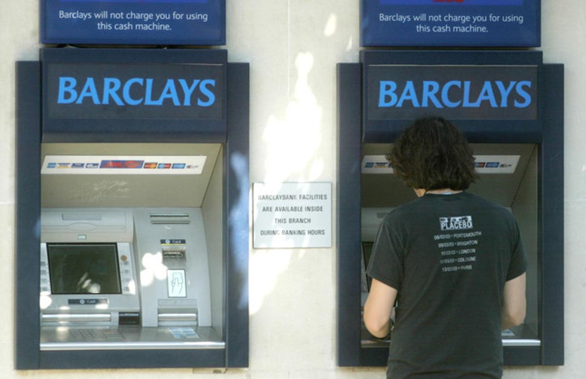 Un jove treu diners d’un caixer de Barclays Bank a Londres. Un jove treu diners d’un caixer de Barclays Bank a Londres.