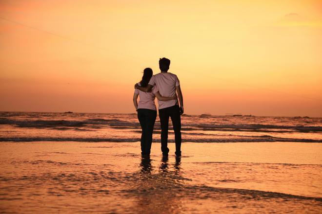 Pareja viendo el atardecer en la playa