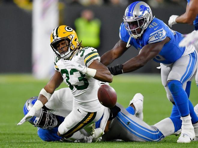 Aaron Jones # 33 de los Green Bay Packers pierde el balón en el primer cuarto contra los Detroit Lions en Lambeau Field.