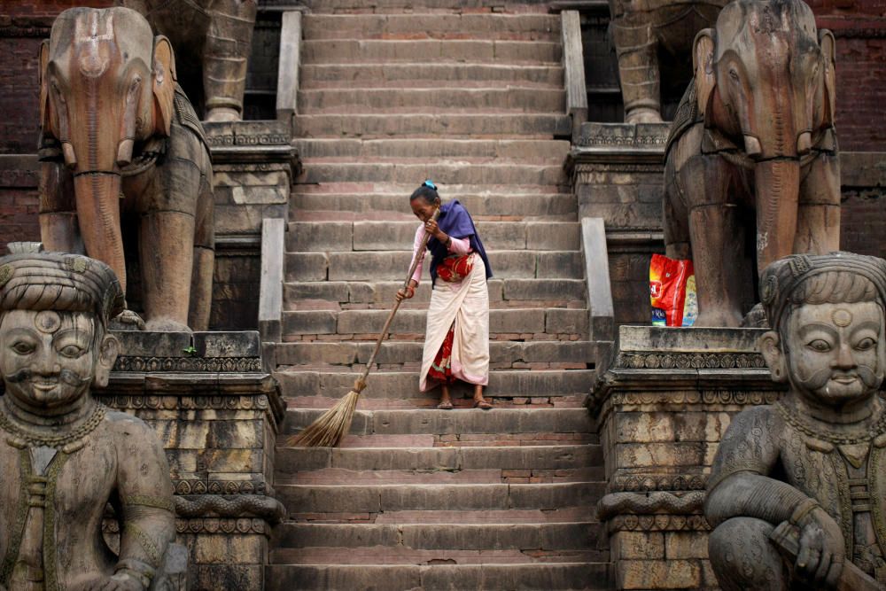 Una mujer barre las instalaciones del templo de Nyatapola en Bhaktapur, Nepal.