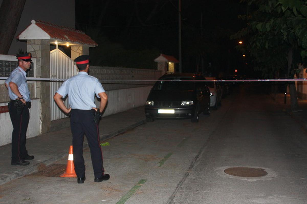Dos agents dels Mossos d’Esquadra controlen el cordó policial instal·lat aquest dimecres a la nit a Castelldefels arran de la mort de quatre membres d’una família.