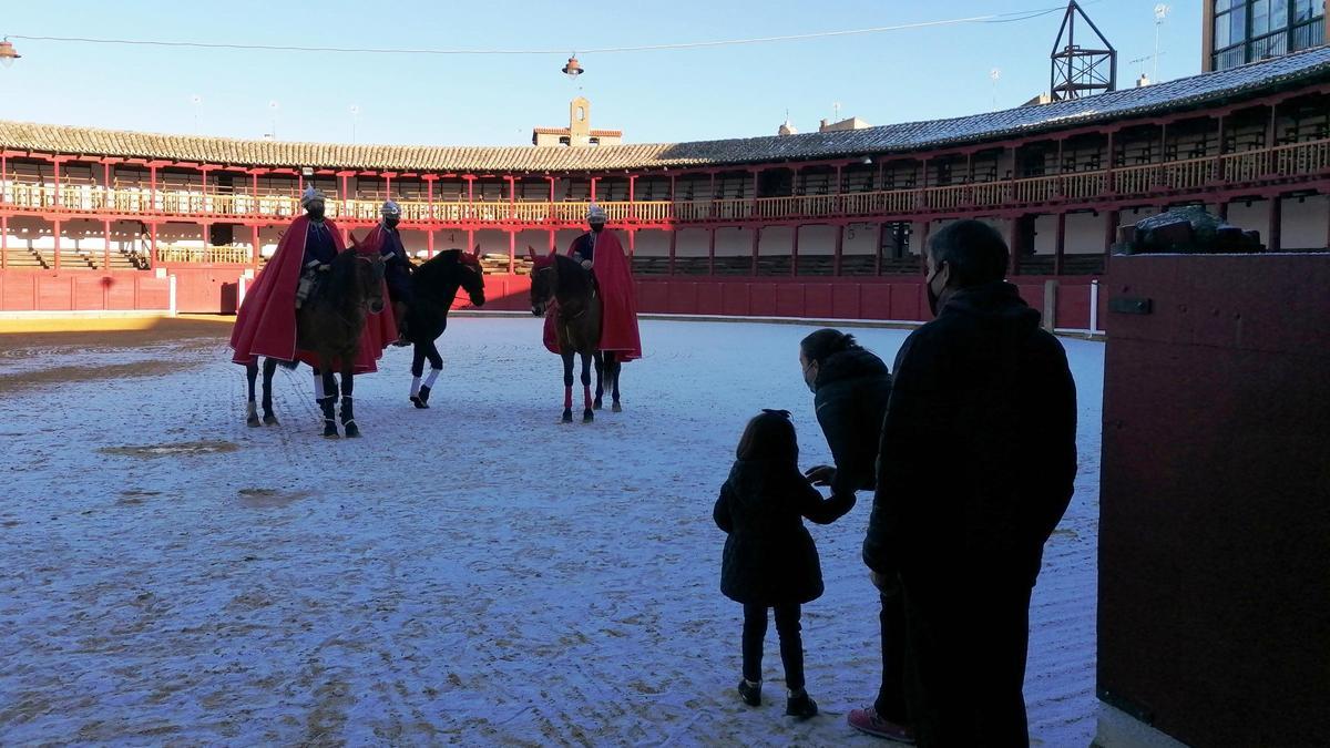 Una niña, acompañada de sus padres, saluda a los pajes reales