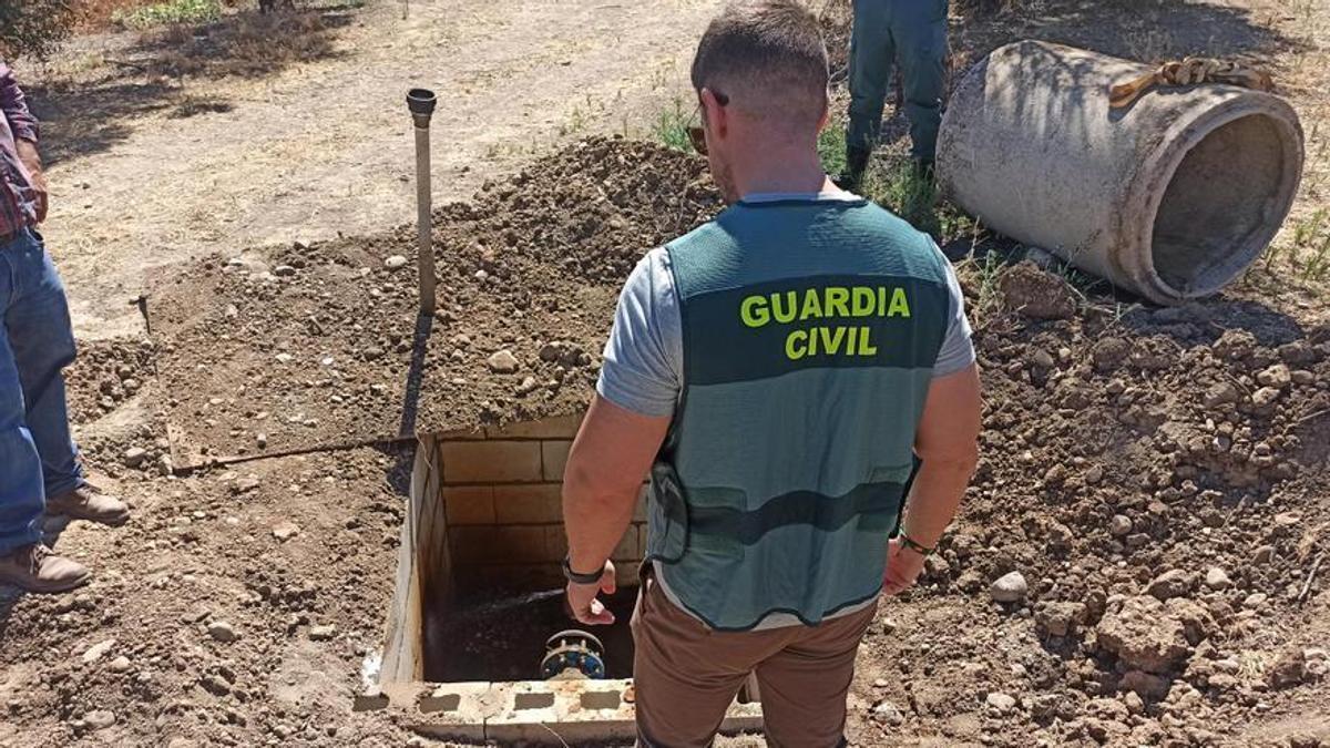 Un agente de la Guardia Civil observa un pozo clandestino.