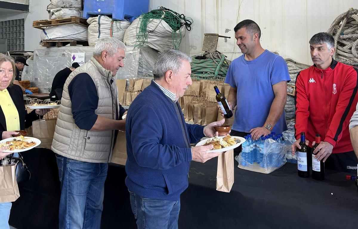 Comensales recogiendo sus raciones de congrio en la fiesta gastronómica de Muxía.