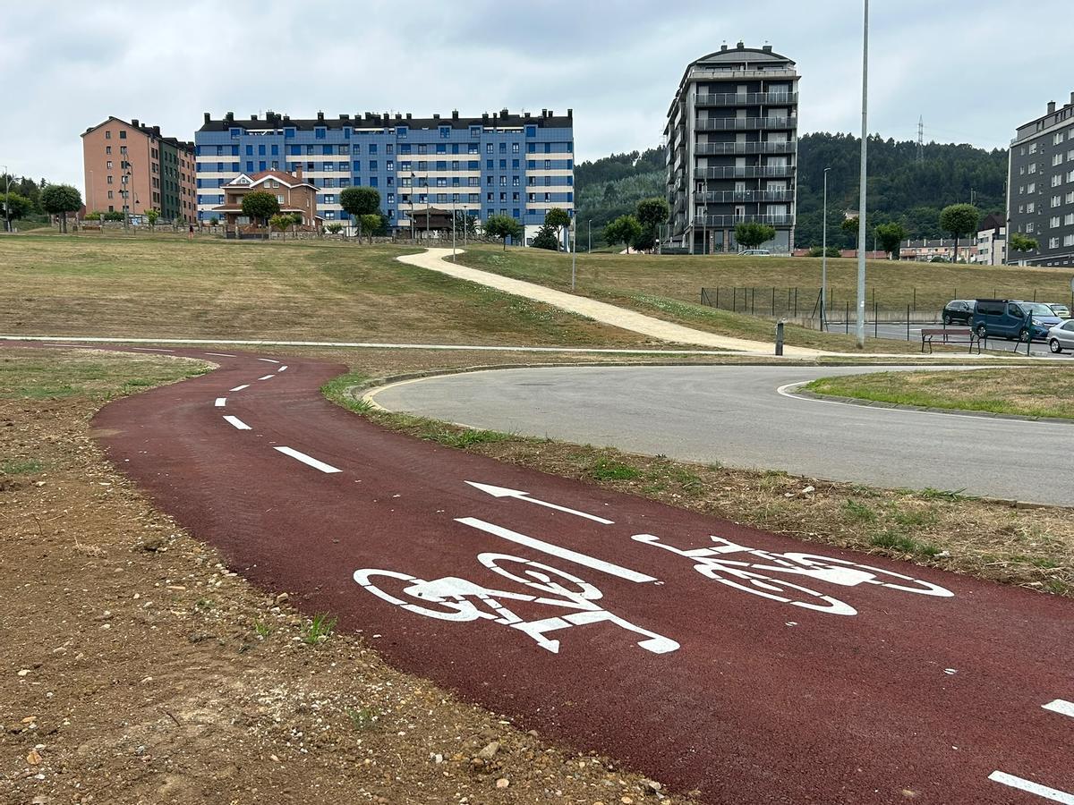 En primer plano, el nuevo carril bici que conecta Corvera y Avilés, con la pista finlandesa al fondo.