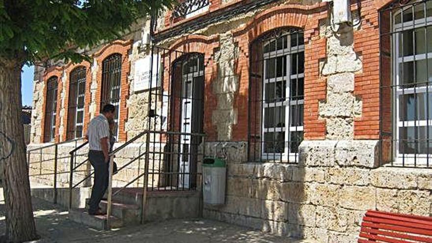 Dos vecinos acceden por las escaleras al interior del colegio de Morales de Toro.