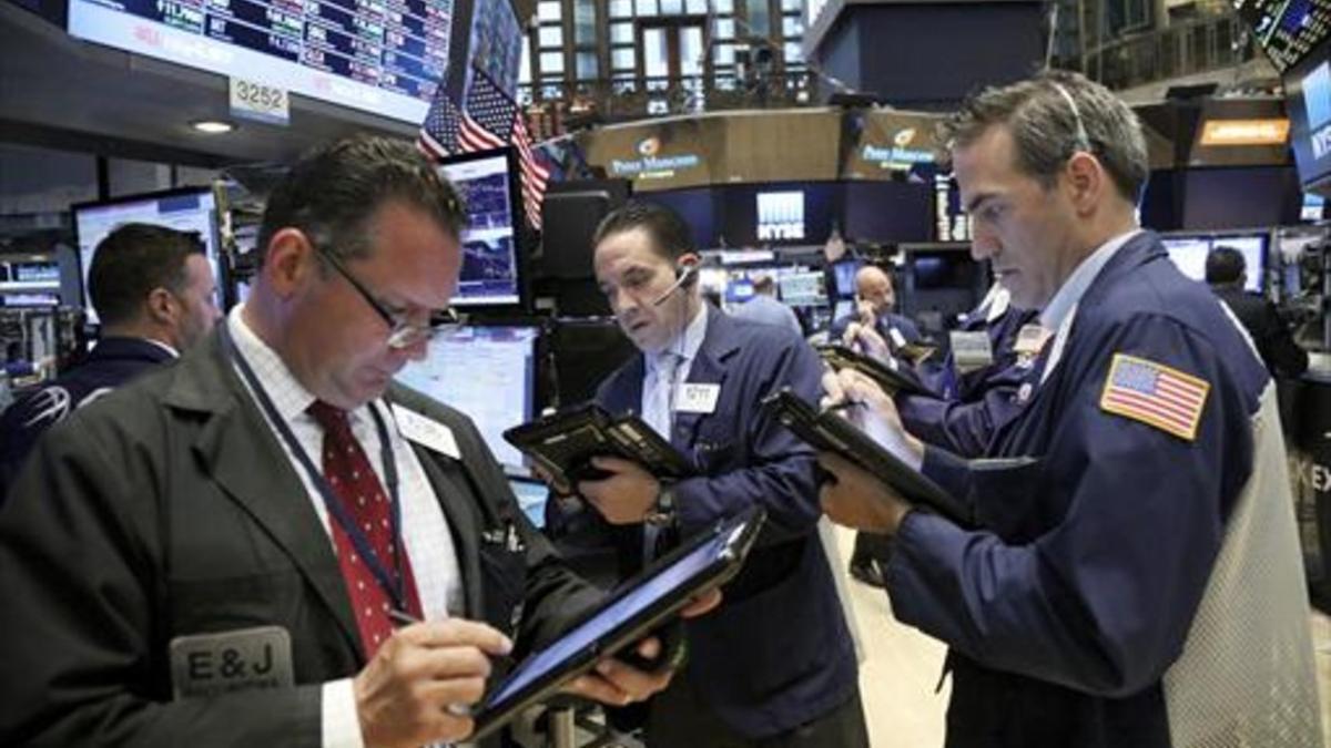 Agentes de bolsa en Wall Street, atentos ayer a la evolución de los mercados.
