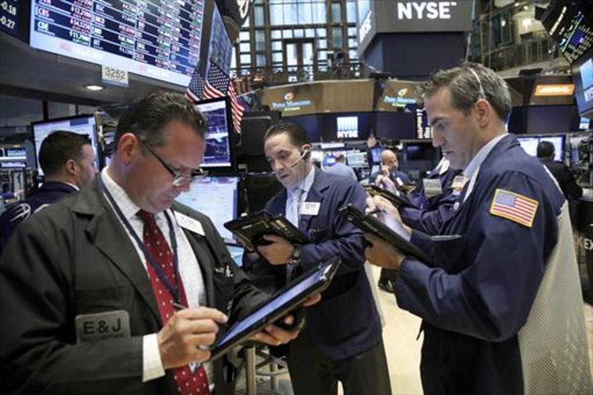 Agentes de bolsa en Wall Street, atentos ayer a la evolución de los mercados.