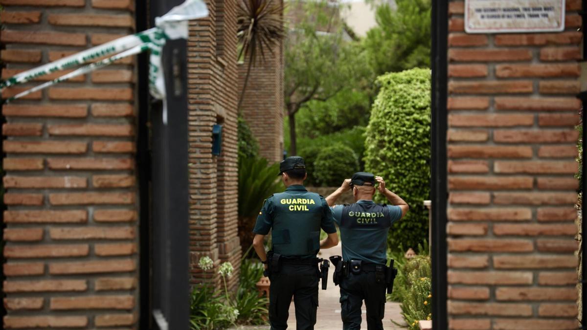 Dos agentes de la Guardia Civil en la vivienda de la urbanización de Los Arqueros, en Benahavís, donde ha sido hallada una mujer de 45 años muerta con signos de violencia. La víctima presenta en principio un corte en el cuello por arma blanca