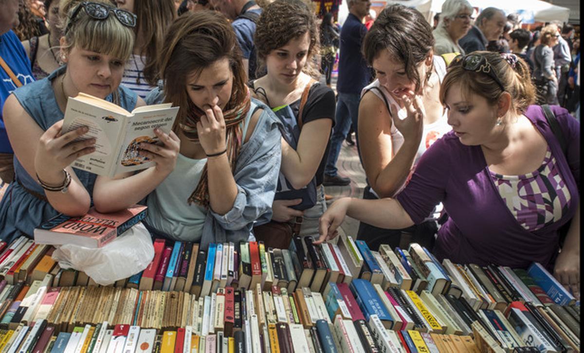 Un grup de dones consulta diversos llibres en una parada de Barcelona.