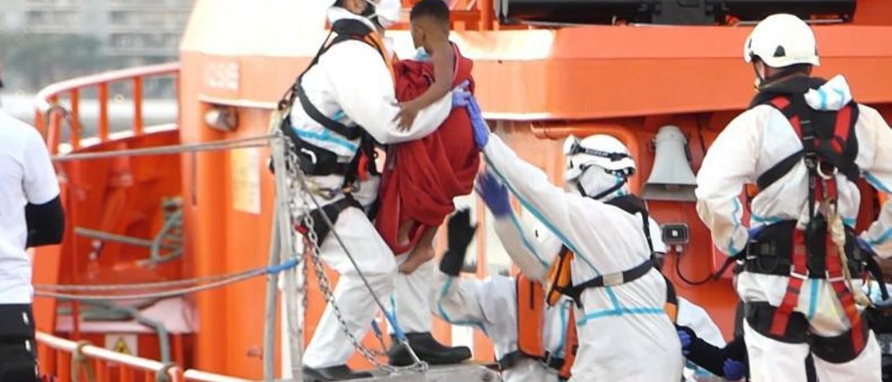 Miembros de Salvamento Marítimo  ayudan a un menor a bajar de la guardamar en Arguineguín. | | EUROPA PRESS