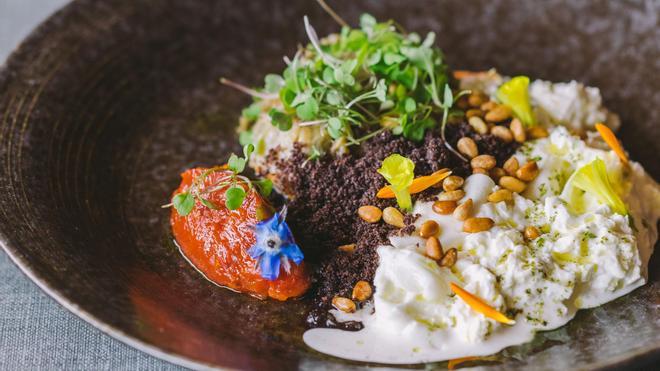 Ensalada de burrata, berenjena confitada, tomate marinado, tierra de aceitunas negras y rúcula del restaurante 1497.