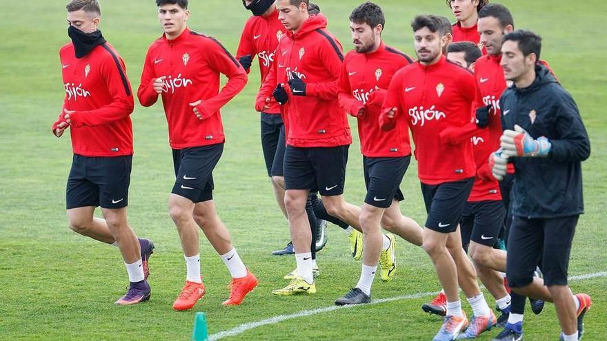 Los jugadores del Sporting realizan ejercicios de calentamiento.