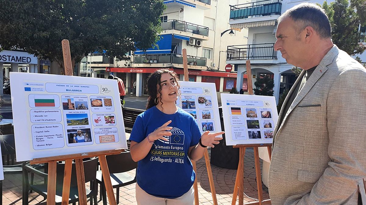 El alcalde de Altea recibe explicaciones de una alumna en el Día de Europa.
